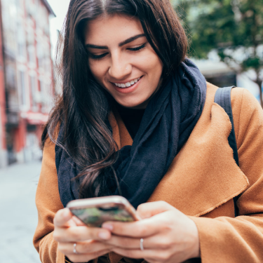 Woman looking at a travel app on her phone while travelling.